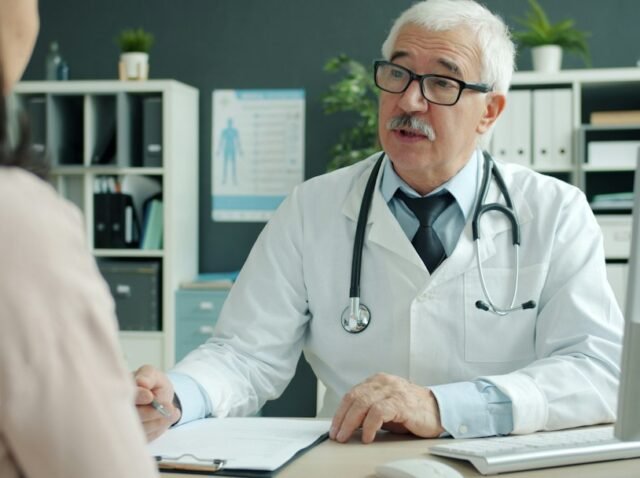 Clinic manager reviewing patient acquisition cost data with a doctor in a modern office