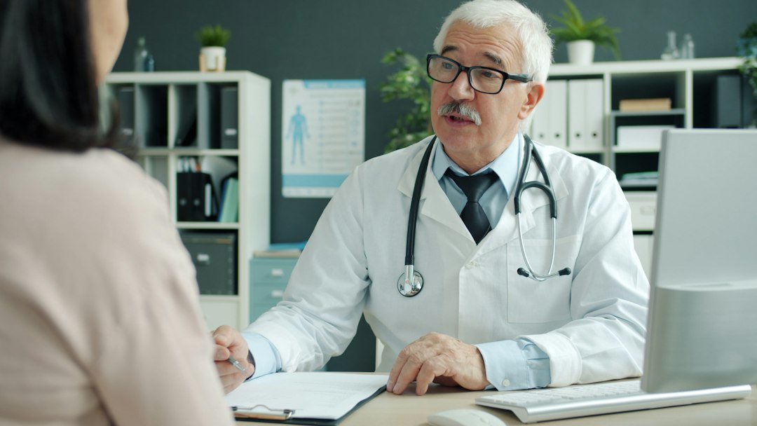 Clinic manager reviewing patient acquisition cost data with a doctor in a modern office Clinic manager reviewing patient acquisition cost data with a doctor in a modern office
