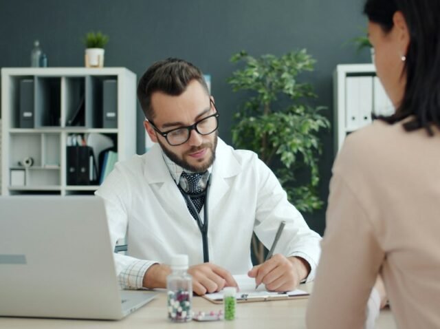 Clinic manager reviewing patient reviews and online reputation on a laptop in a modern medical office