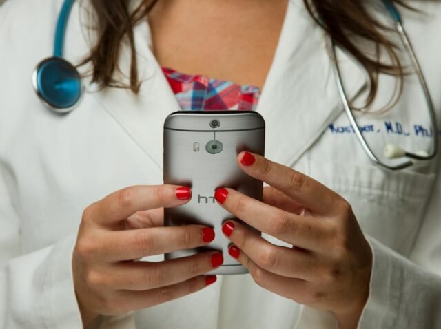 Clinic coordinator replying to an international patient inquiry on a smartphone