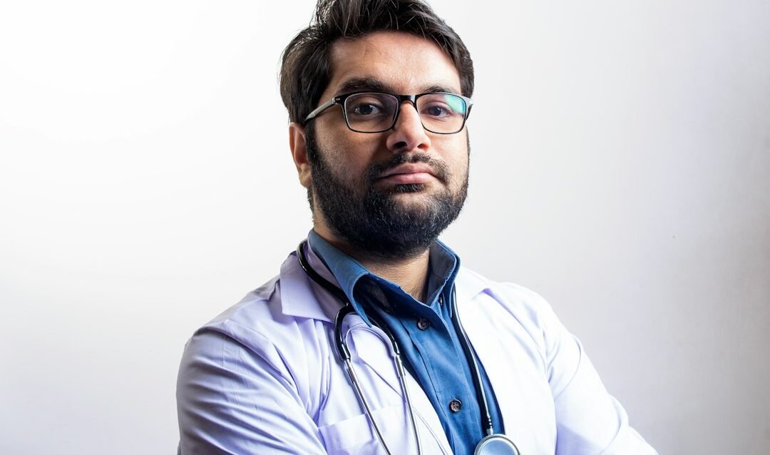 Physician reviewing a personal brand website and professional profile on a laptop in a modern clinic office Physician reviewing a personal brand website and professional profile on a laptop in a modern clinic office
