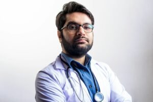 Physician reviewing a personal brand website and professional profile on a laptop in a modern clinic office