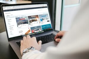 Klinikte dizüstü bilgisayarda web sitesi tasarımını inceleyen doktor
