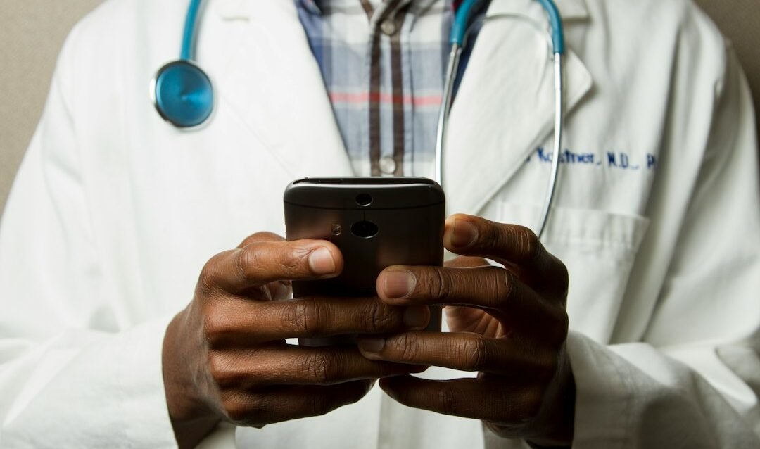 Klinikte akıllı telefonla hasta mesajlarını yanıtlayan sağlık çalışanı Klinikte akıllı telefonla hasta mesajlarını yanıtlayan sağlık çalışanı